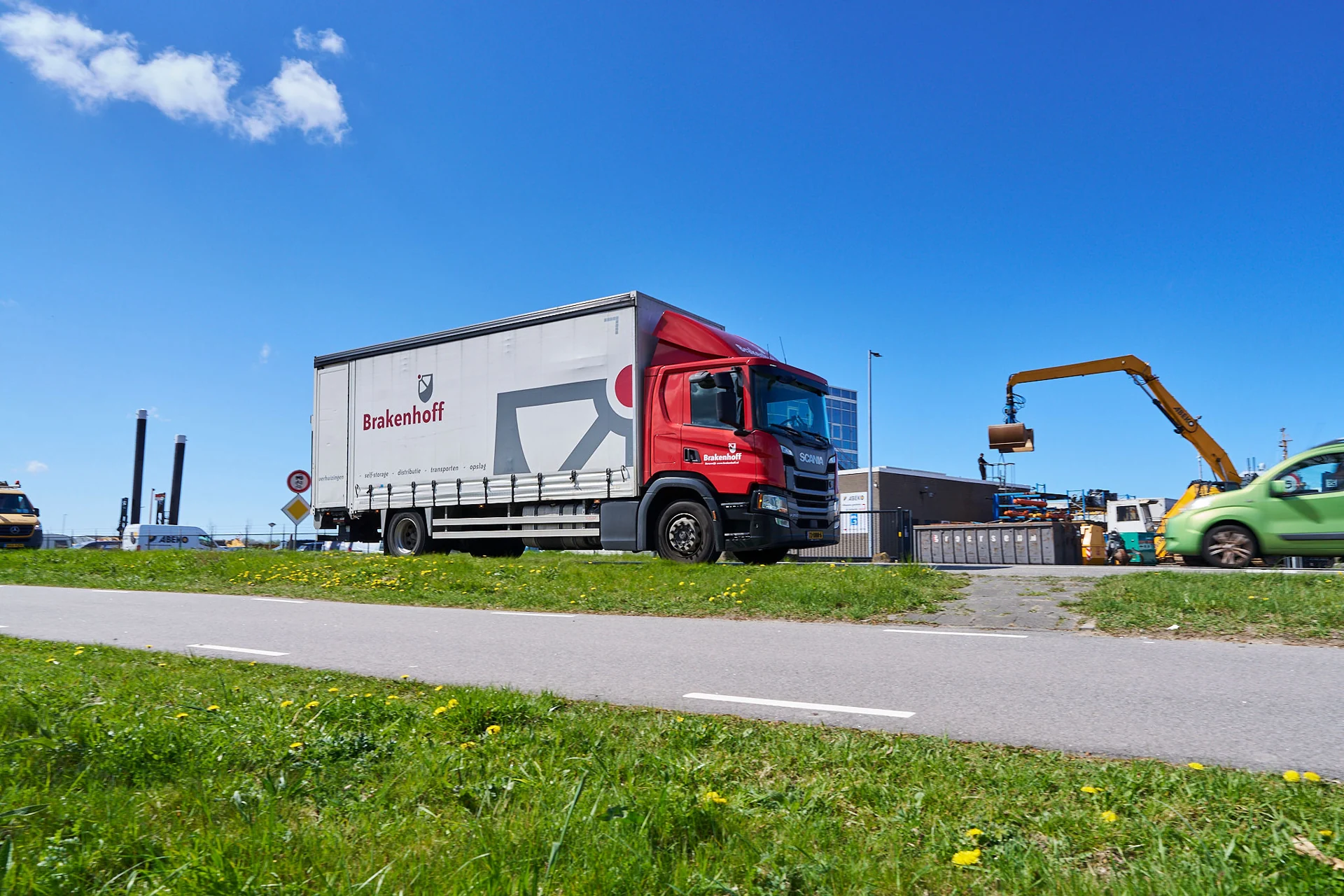 Rode Brakenhoff-vrachtwagen op de weg bij het bedrijventerrein